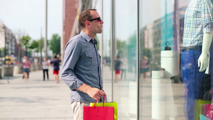 A man looking in shop window to represent how social media should entice readers to your website