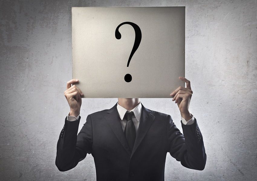 A man holding a question mark over his head to show how social media can be used to make more detailed buyer personas